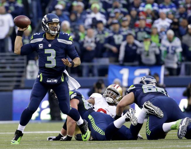 Seattle Seahawks' Russell Wilson throws during the first half of the NFL football NFC Championship game against the San Francisco 49ers Sunday, Jan. 19, 2014, in Seattle. (AP Photo/Ted S. Warren)